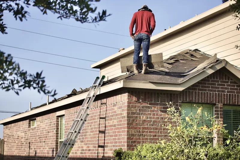 Professional roofer working on a residential roof in Schall Circle